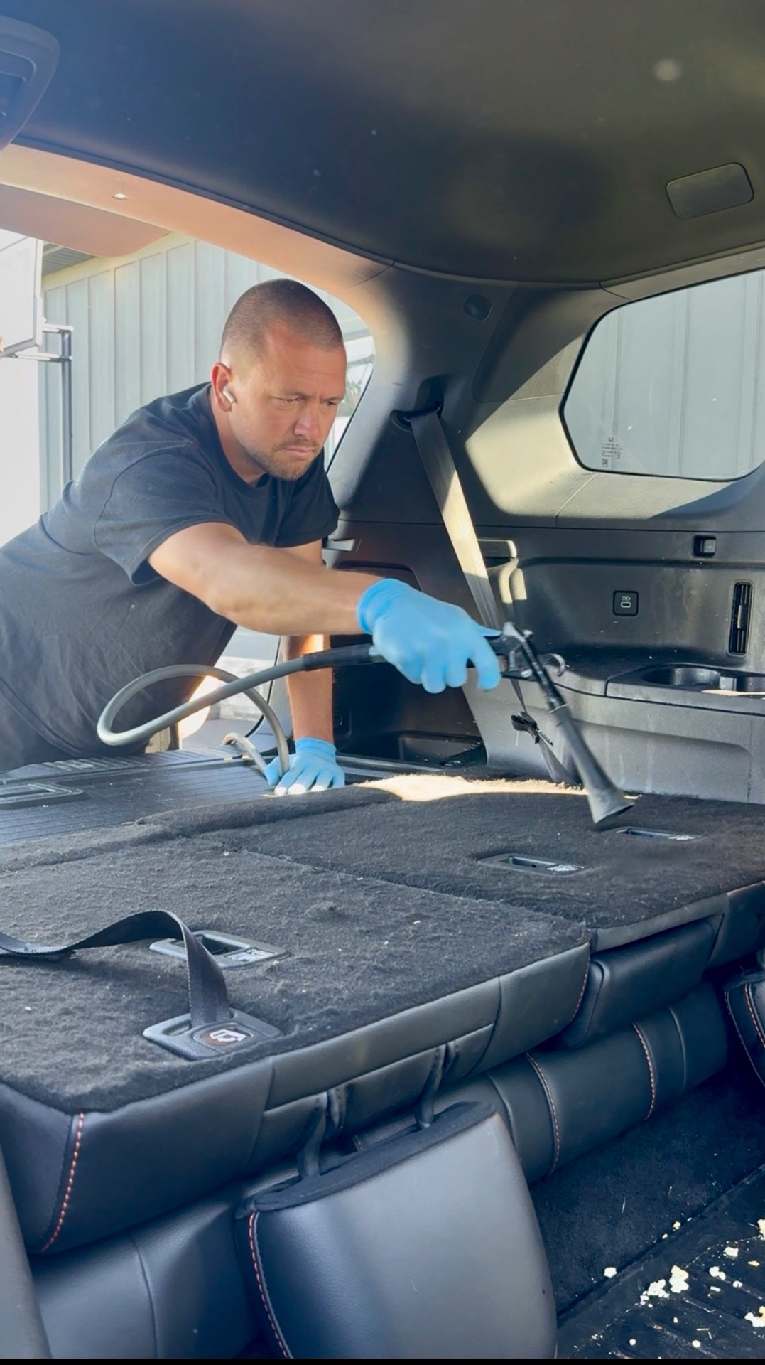 PRO DTLR detailer cleaning a vehicle interior during a mobile appointment