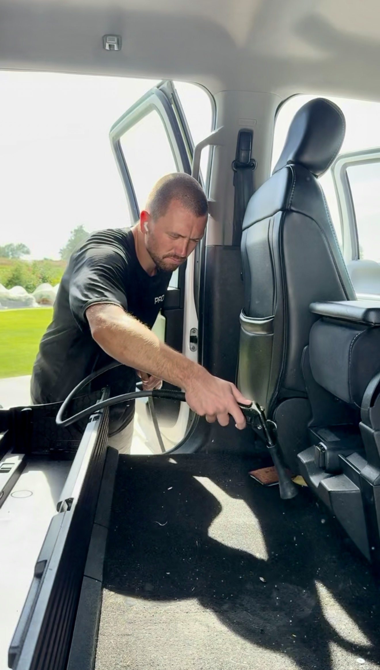 PRO DTLR detailer cleaning the backseat and floor mats of a vehicle's interior