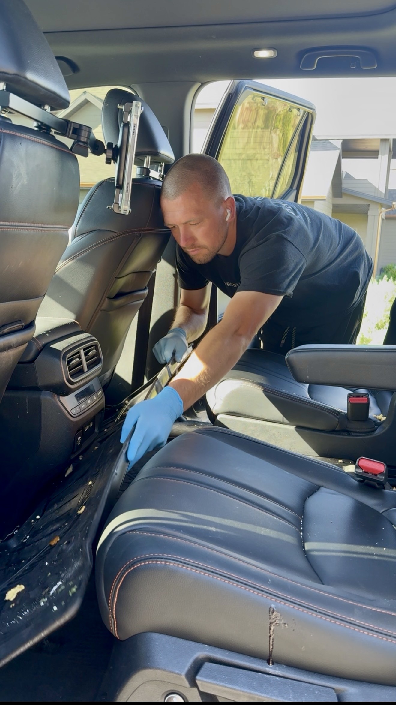 PRO DTLR detailer cleaning the interior console and seats of an SUV during mobile car detailing in Rexburg, Idaho